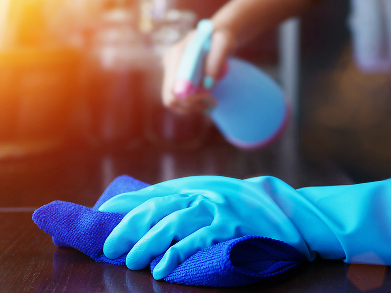 person wearing blue glove cleaning surface casa grande az